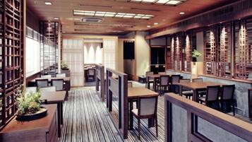 Un restaurante moderno con paneles de madera, suelo a rayas y varias zonas de comedor.