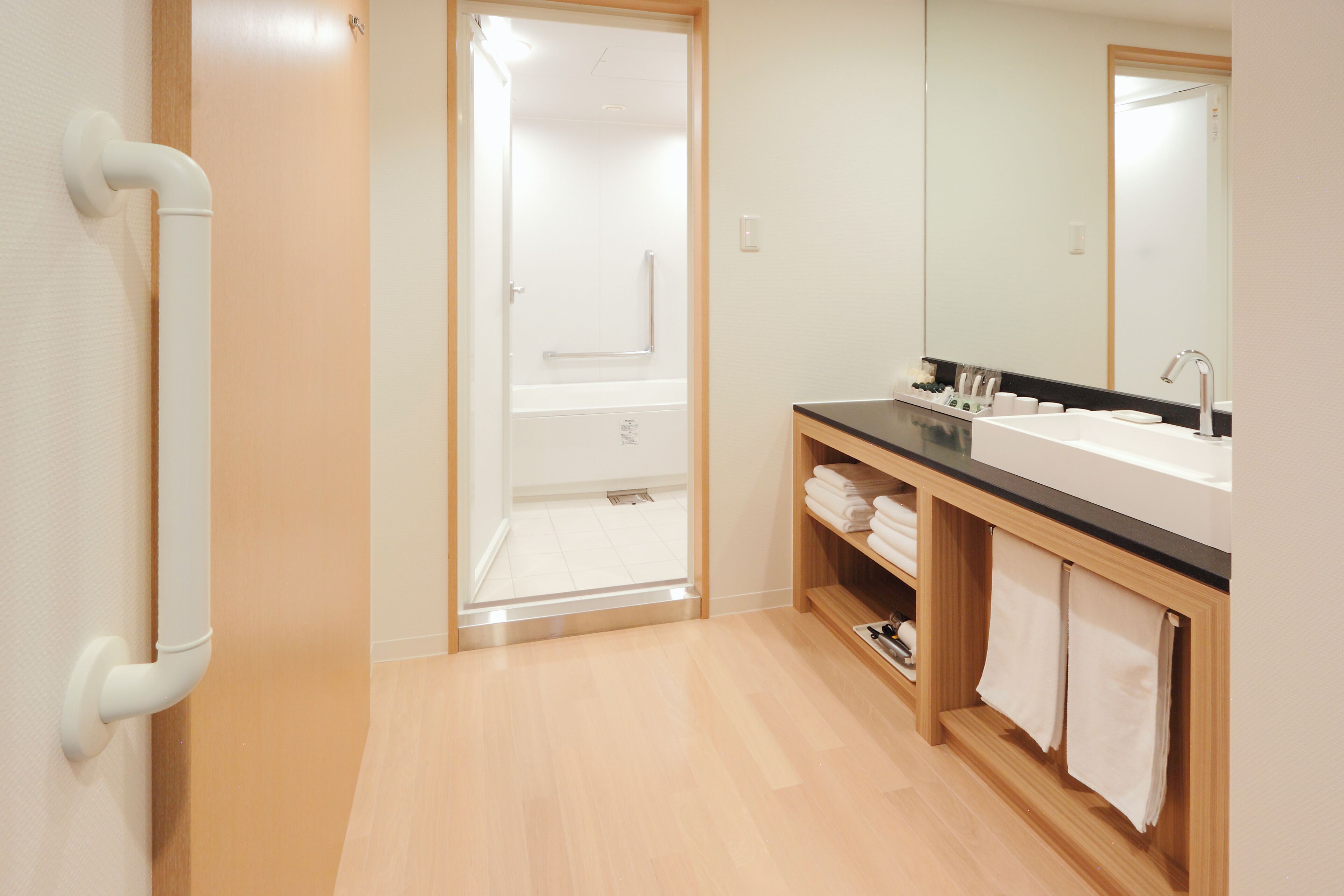 A modern bathroom with a shower, a sink, and a mirror.