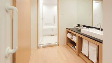 A modern bathroom with a shower, a sink, and a mirror.