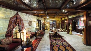 Ein traditionelles Interieur mit gemusterten Teppichen, Holzmöbeln und dekorativen Gegenständen.