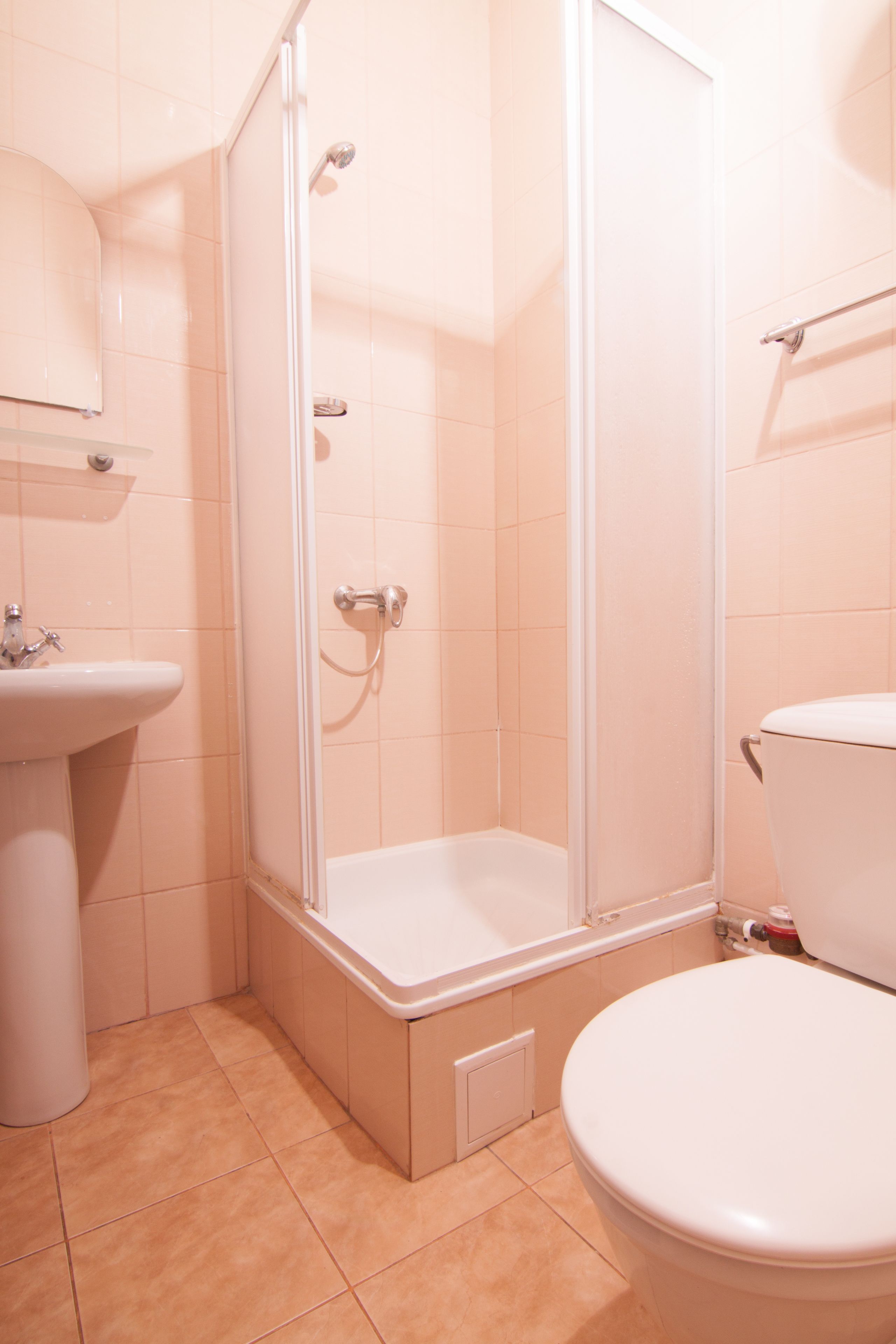 A bathroom with a shower, sink, and toilet.