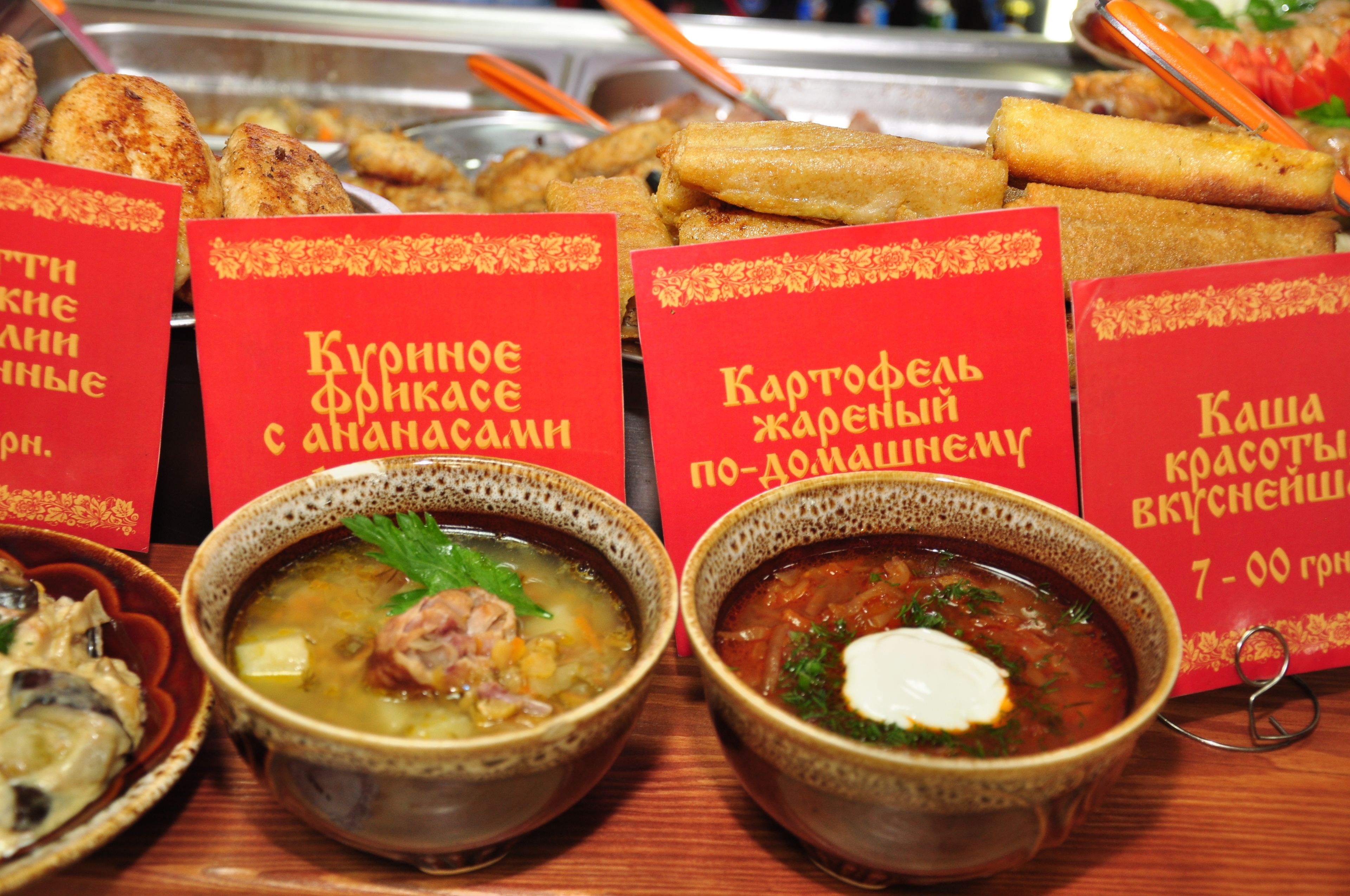 A variety of food items including soups and fried snacks, with red signs indicating different types of dishes.