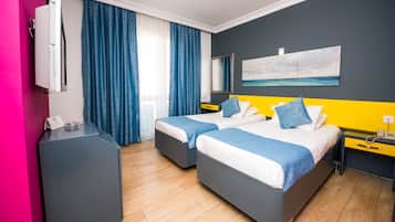 Habitación de hotel con dos camas, un escritorio, un espejo y un cuadro de playa.