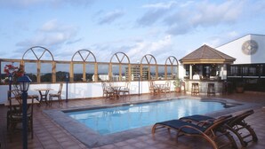 A rooftop pool area with a bar, seating, and a view of the cityscape. - Royal Court Hotel (Mombasa)