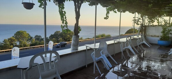 A terrace with a view of the sea, outdoor seating, and a sign indicating a Dallas hotel. - Dallas Hotel (Marmara Ereglisi)