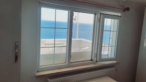 A room with a large window overlooking a coastal view. - Dallas Hotel (Marmara Ereglisi)