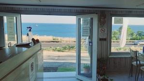 A room with a view of the sea, a reception desk, and a dining area with chairs and a table. - Dallas Hotel (Marmara Ereglisi)