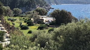 Une propriété située sur la côte, dotée d’un jardin, d’un sentier en pierre et offrant une vue sur la mer et les montagnes.