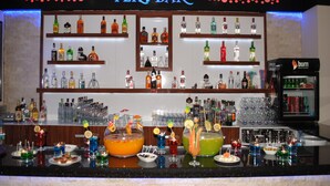 Un bar con una variedad de botellas de licor y una selección de cócteles coloridos.