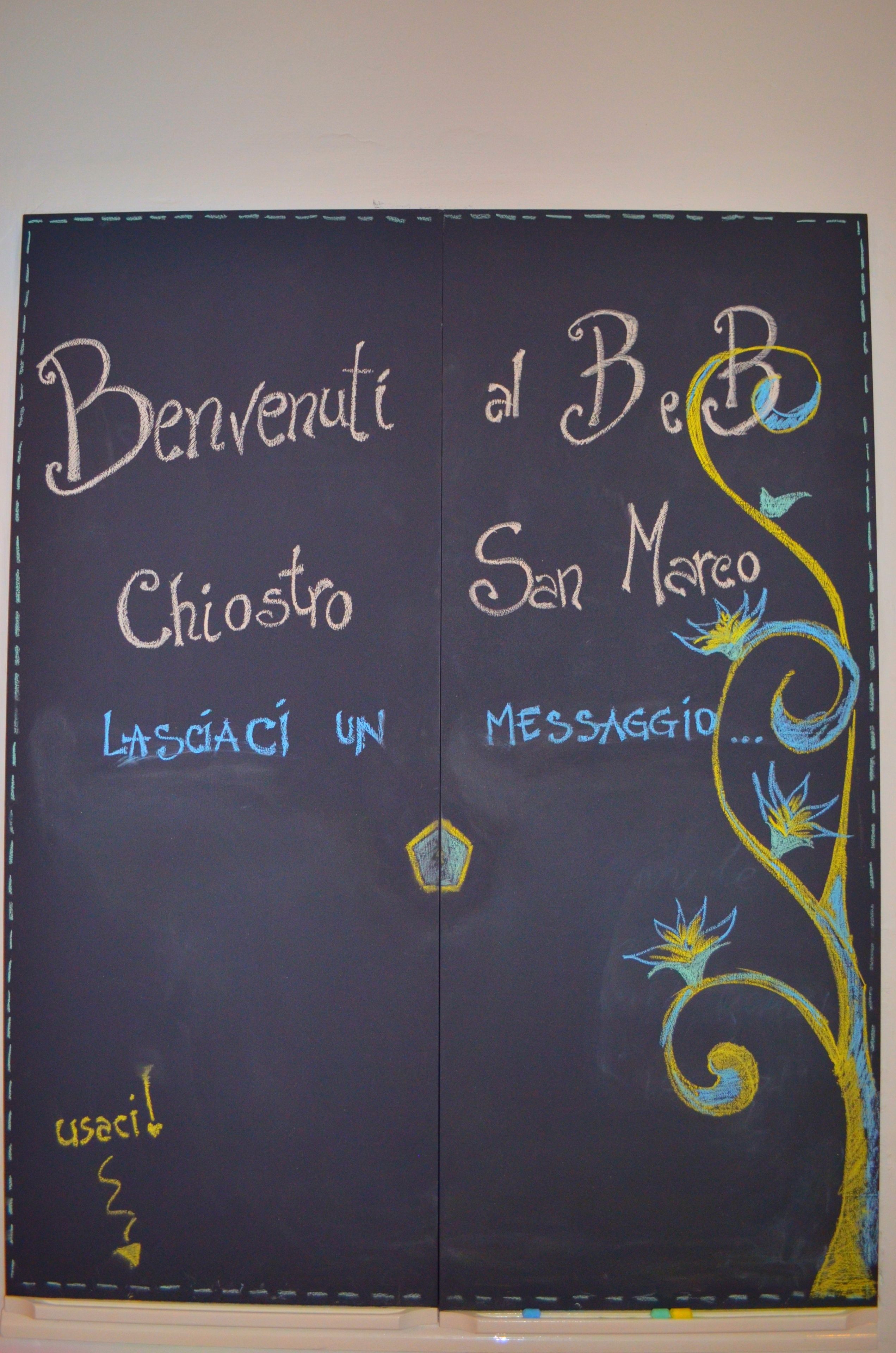 Tavle med teksten "Benvenuti al BeB San Marco" og "Lasciaci un messaggio".