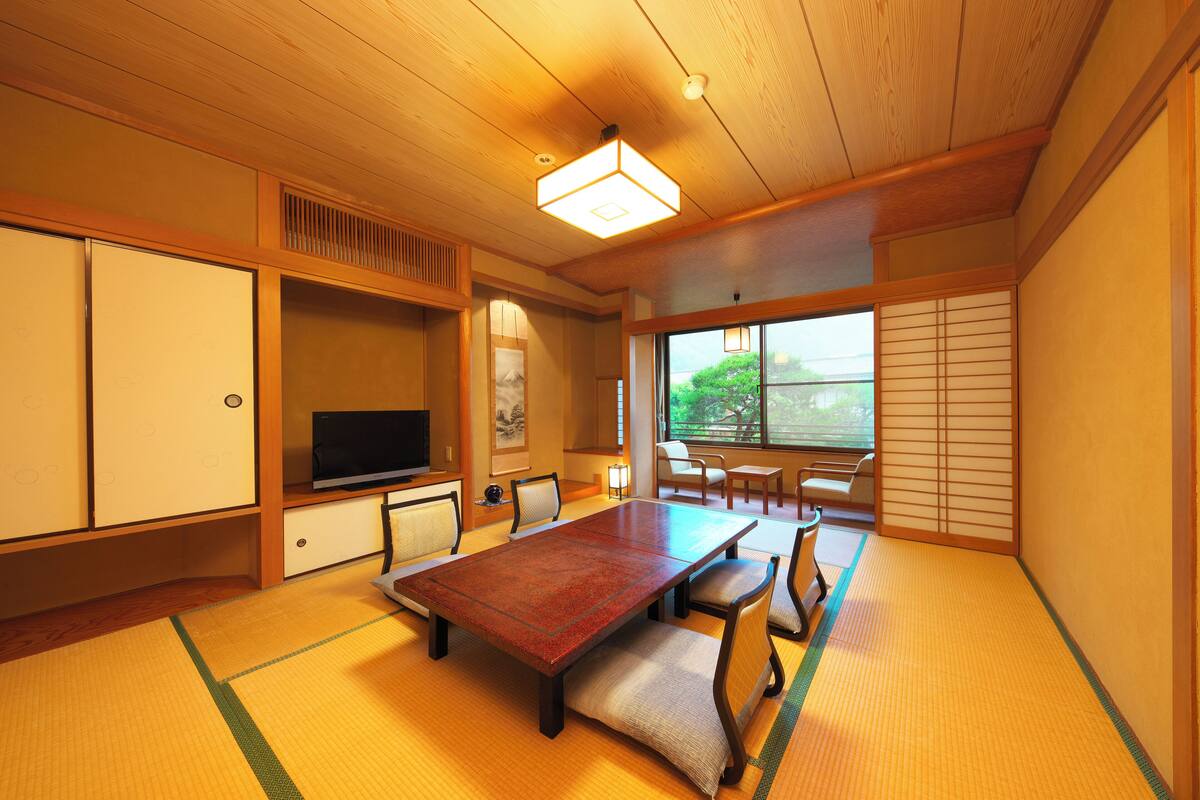 A traditional Japanese room with tatami flooring, a low table, and sliding doors.