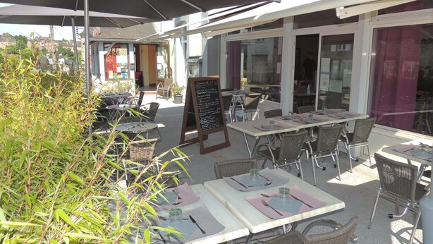 An outdoor café with tables and chairs, a menu board, and a view of the surrounding area. - Le Gue De Genes (Ambrières-les-Vallées)