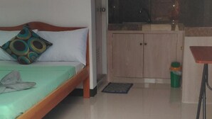 A bedroom with a bed, a bedside table, a small window, and a wall clock. - Sealor Pension House (Puerto Princesa)