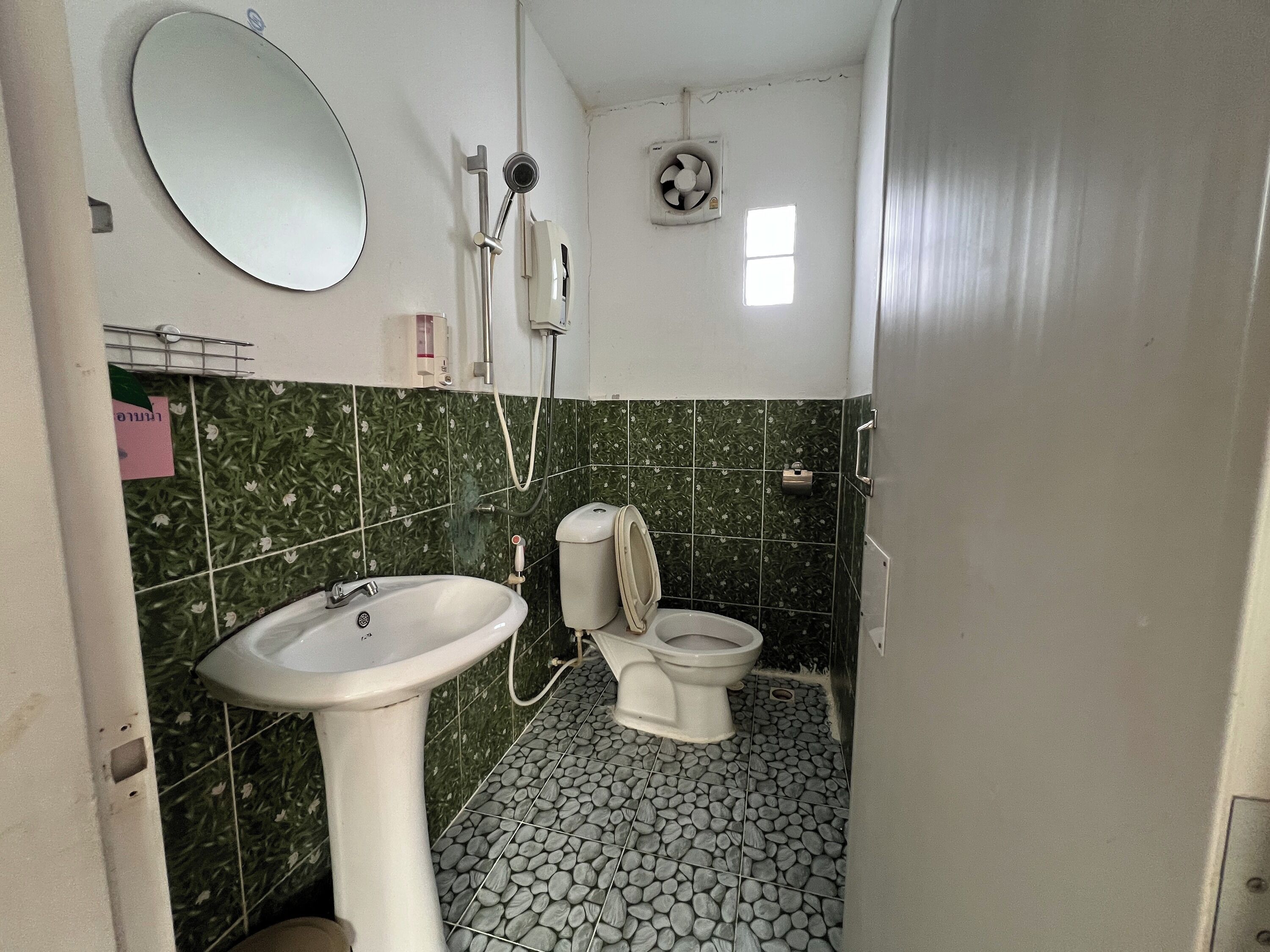 A small bathroom with a sink, toilet, and shower.