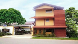 A multi-story hotel with a yellow facade and a red upper section. - Coconut Home Resort (Bang Khonthi)