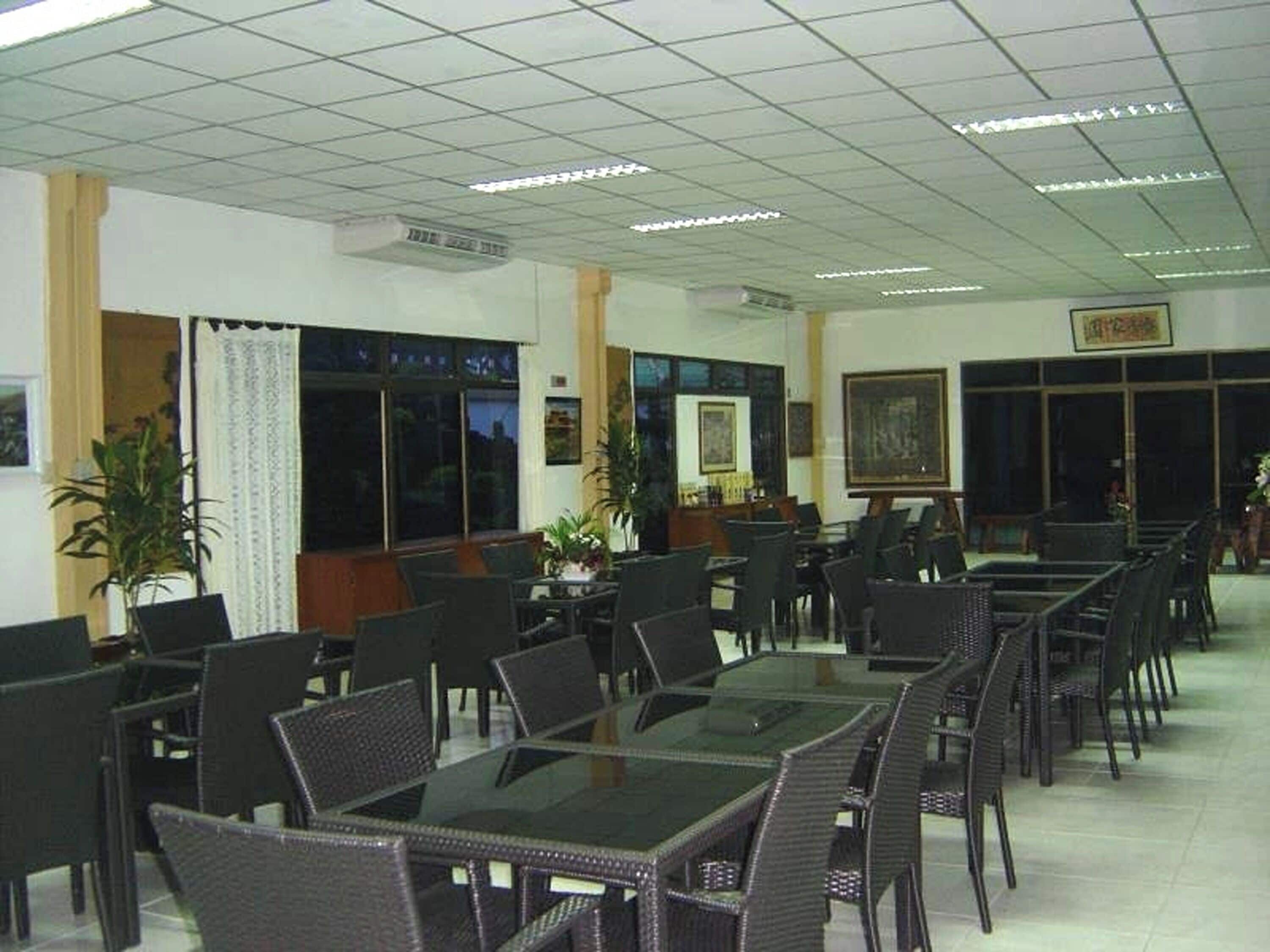 Un salón de conferencias con mesas y sillas de cristal, ventanas amplias y obras de arte enmarcadas en las paredes.