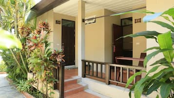 A hotel entrance with a covered porch, steps leading to the door, and a sign indicating room number 16.