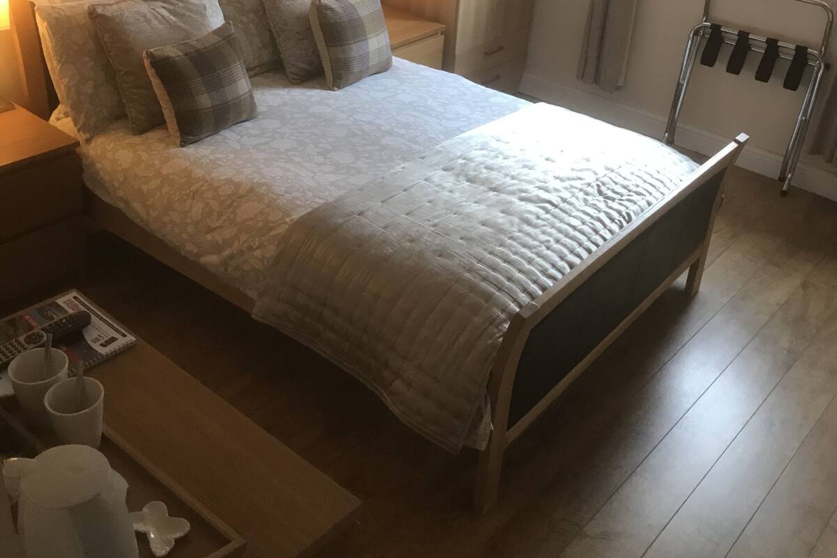 A bedroom with a bed, bedside tables, a wardrobe, and a radiator.