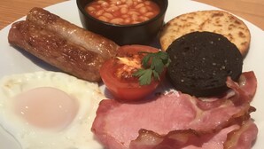 A plate of breakfast food including eggs, bacon, sausages, beans, a black pudding, a fried tomato, and a slice of toast. - Valhalla B&B (Alexandria)