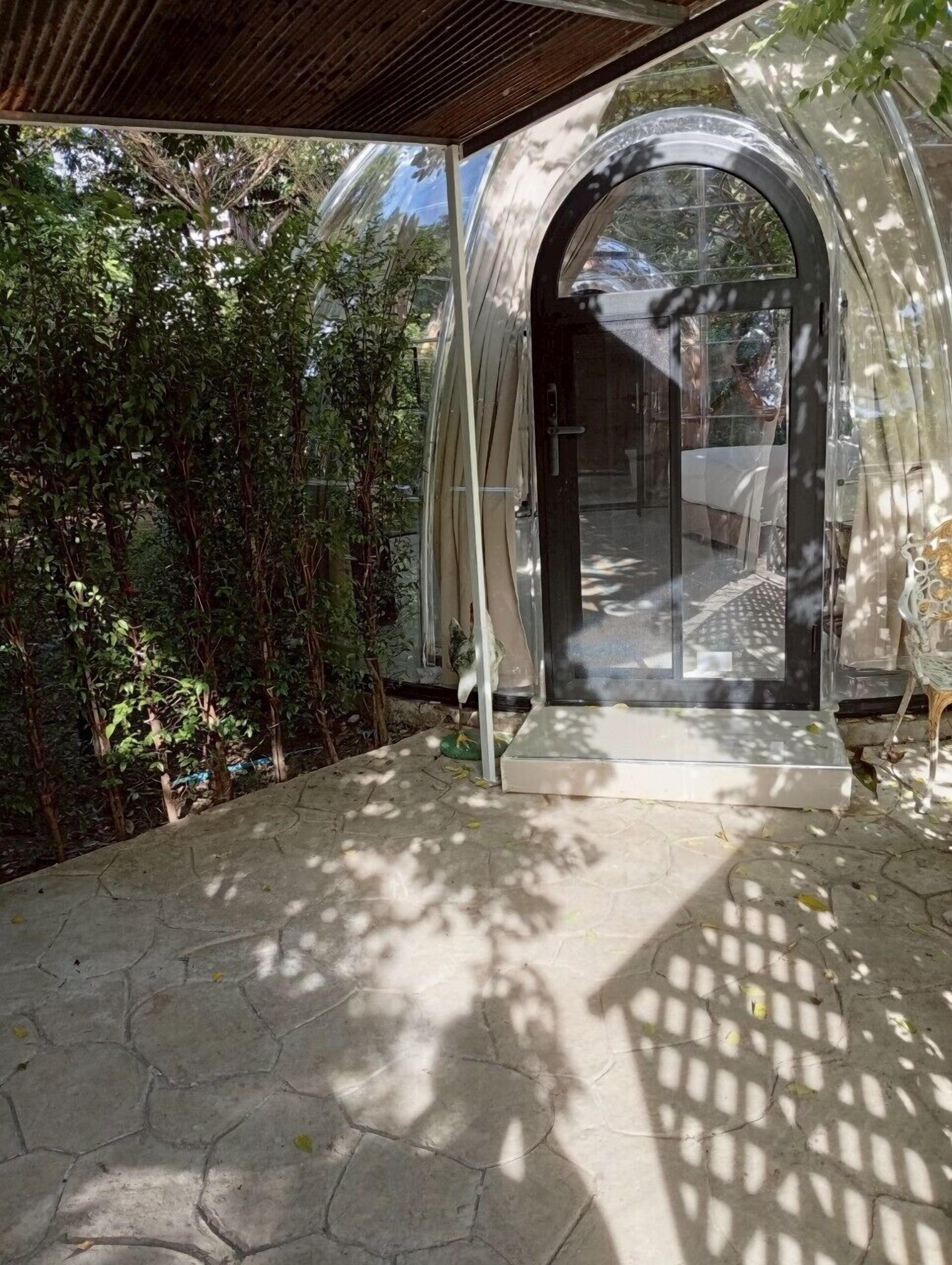 A covered outdoor area with a glass door leading to an interior space.
