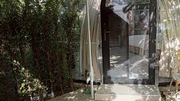 A covered outdoor area with a glass door leading to an interior space.