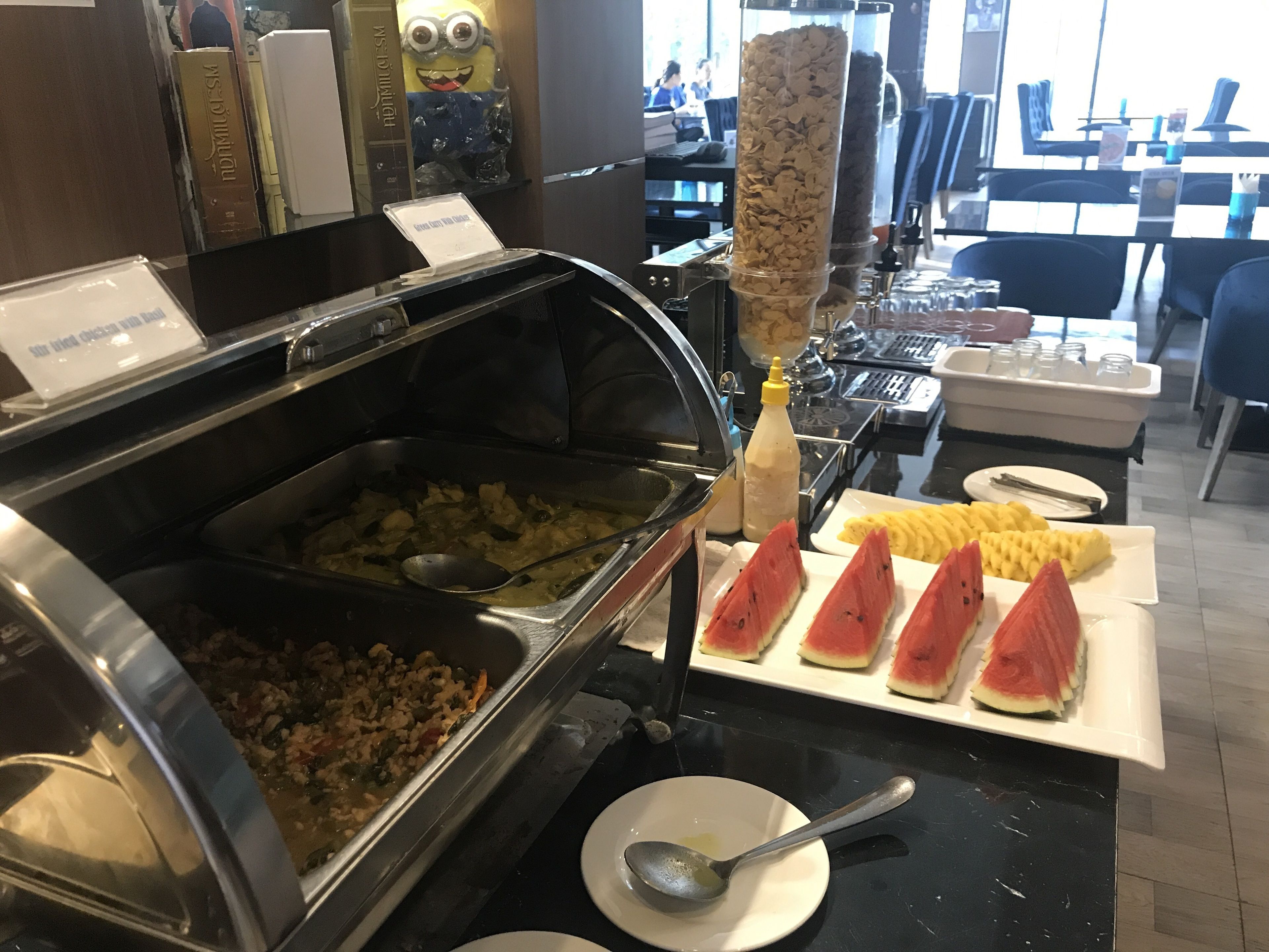 A buffet with various food items including a salad, a hot dish, and sliced watermelon.