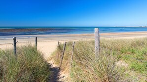 A sandy beach path with a wooden fence and grass. - Hôtel Ile de Ré (Le Bois-Plage-en-Re)