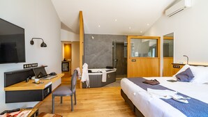 A modern hotel room with a bed, desk, chair, and a small kitchenette. - Hôtel Ile de Ré (Le Bois-Plage-en-Re)