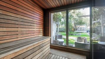Un banco de madera con vista a un jardín y mobiliario de exterior.
