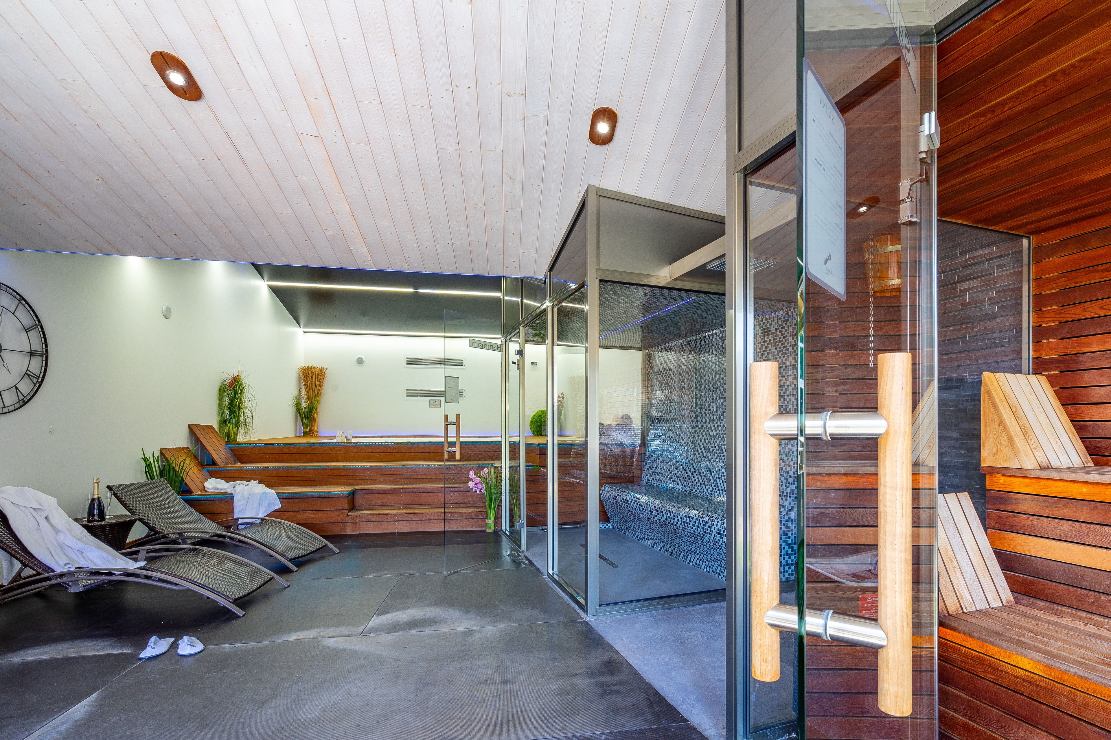 A reception area with a reception desk, seating area with chairs, a clock, and a glass wall.