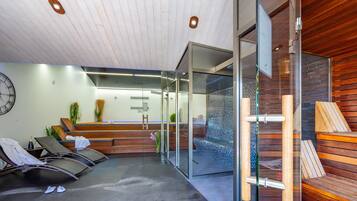 A reception area with a reception desk, seating area with chairs, a clock, and a glass wall.