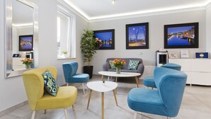 Una sala de estar moderna con sofá, sillas, una mesa de centro y un espejo grande.