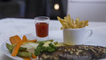 Une assiette avec du poisson, des légumes et une portion de frites.
