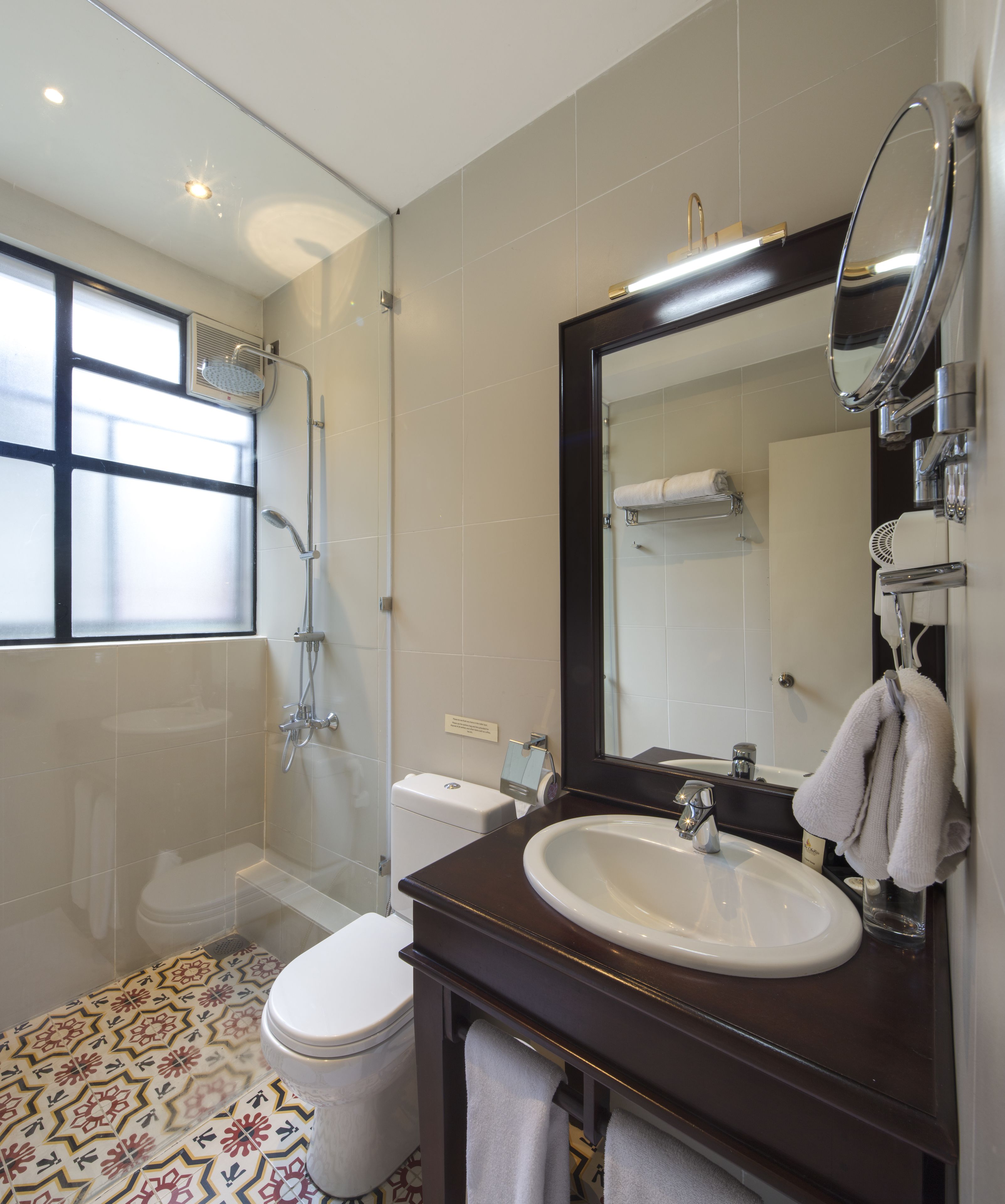 A modern bathroom with a shower, toilet, and sink.