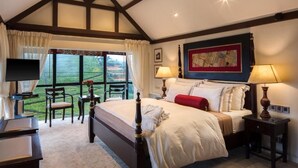 Ein Schlafzimmer mit einem großen Bett, einem Fernseher und Blick ins Freie.