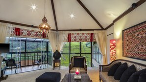 Ein geräumiges Wohnzimmer mit großem Fenster, einem Sofa, einem Couchtisch und einer Chandelier.