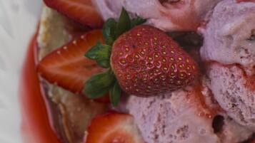 A bowl of ice cream with strawberries on top.