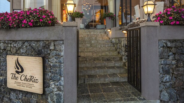 Ein mehrstöckiges Hotel mit einer Steinfassade, einem Schild und einer Treppe zum Eingang.