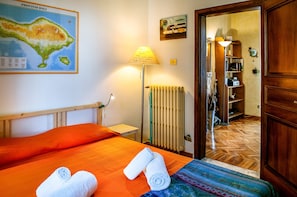 A hotel room with a bed, a map on the wall, a lamp, and a radiator. - Santo Stefano Penthouse (Florence)