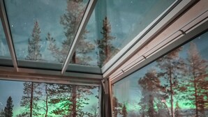 Eine Person liegt in einem Zimmer mit einem großen Fenster in einem Bett.