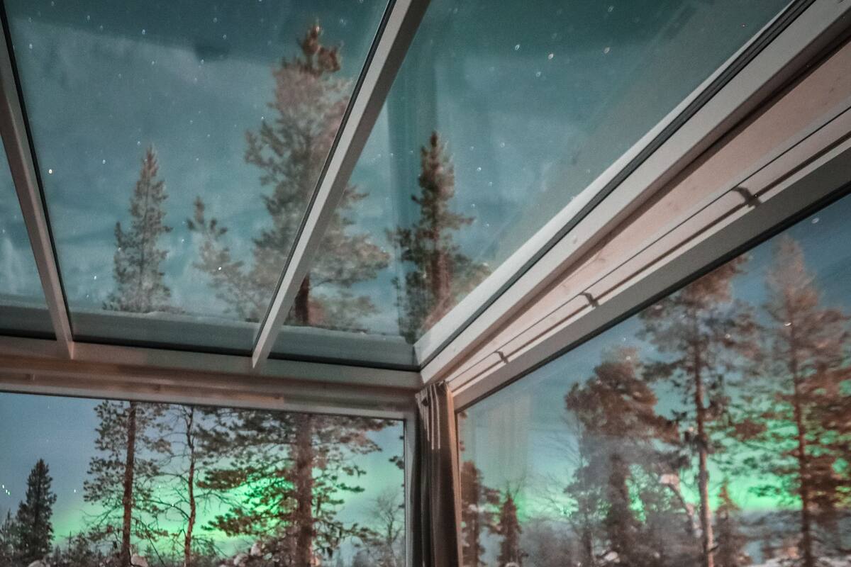 Henkilö makaa sängyllä huoneessa, jossa on suuri ikkuna.