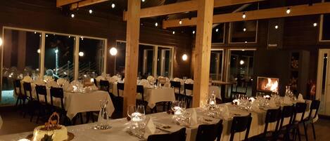 Un restaurant doté de nombreuses tables, avec un plafond haut et de grandes fenêtres.