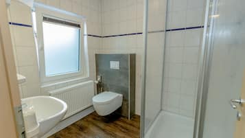 Un baño con bañera, inodoro y ducha.