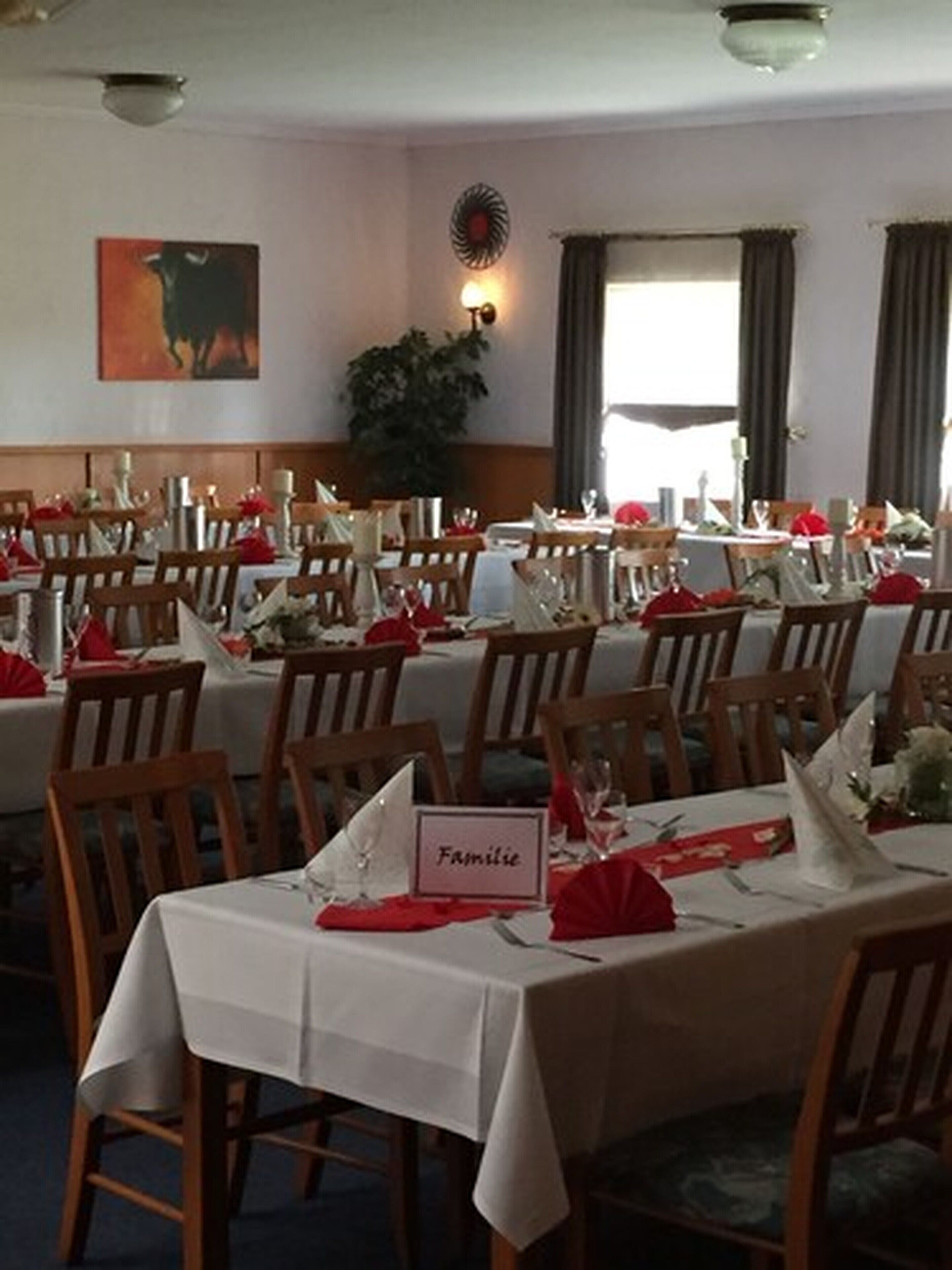 A dining area with multiple tables set for a meal, each with a name card.