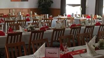 A dining area with multiple tables set for a meal, each with a name card.