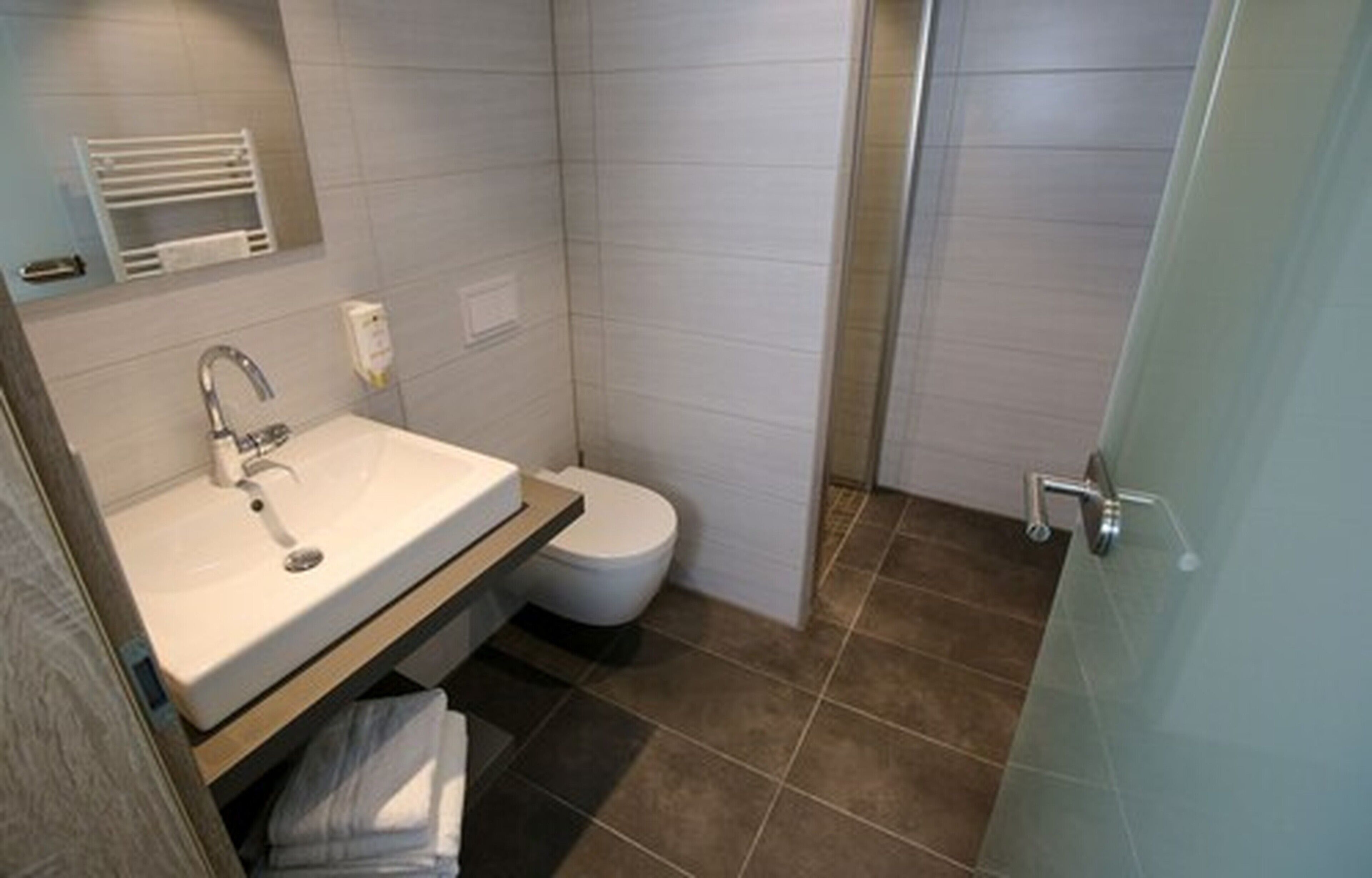 A bathroom with a sink, toilet, and shower.
