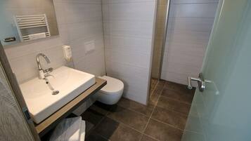 A bathroom with a sink, toilet, and shower.