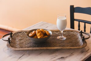 A tray with pastries and a glass of milk on a marble table.