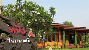 A building with a sign in front, surrounded by greenery and a clear sky. - Nung Ni Bangkonthi (Bang Khonthi)