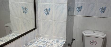 A bathroom with a white sink, a mirror, and a toilet.